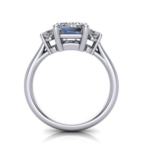 Imogen emerald three stone engagement ring in 18K White Gold, through-finger front profile showing the three-stone head raised above the slim polished shank and trellis gallery
