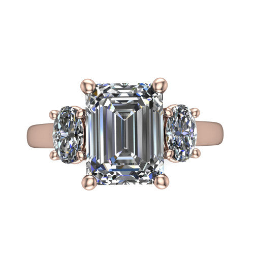 Imogen emerald three stone engagement ring in 18K Rose Gold, top-down view showing the center diamond flanked by two round side stones in a classic three stone setting