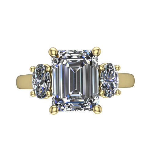 Imogen emerald three stone engagement ring in 18K Yellow Gold, top-down view showing the center diamond flanked by two round side stones in a classic three stone setting