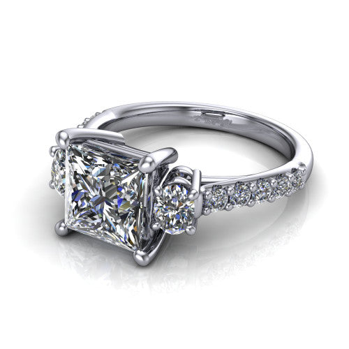 Poppy princess three stone engagement ring in Platinum, three-quarter perspective showing the center diamond between two round side stones above a pav&eacute; shank