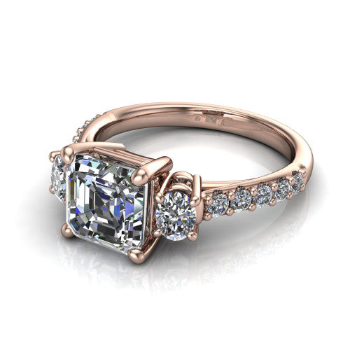 Poppy asscher three stone engagement ring in 14K Rose Gold, three-quarter perspective showing the center diamond between two round side stones above a pav&eacute; shank