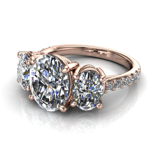 Poppy oval three stone engagement ring in 18K Rose Gold, three-quarter perspective showing the center diamond between two round side stones above a pav&eacute; shank