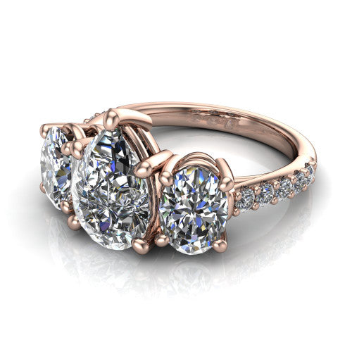 Poppy pear three stone engagement ring in 18K Rose Gold, three-quarter perspective showing the center diamond between two round side stones above a pav&eacute; shank