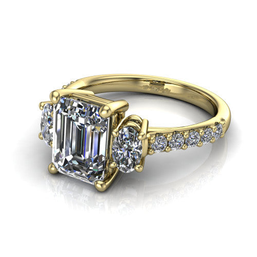 Poppy emerald three stone engagement ring in 14K Yellow Gold, three-quarter perspective showing the center diamond between two round side stones above a pav&eacute; shank
