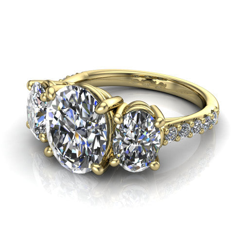 Poppy oval three stone engagement ring in 18K Yellow Gold, three-quarter perspective showing the center diamond between two round side stones above a pav&eacute; shank