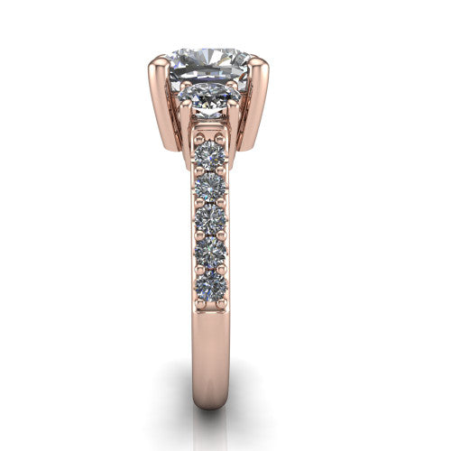 Poppy cushion three stone engagement ring in 14K Rose Gold, side profile showing the round side stone and the pav&eacute; diamonds running down the shank