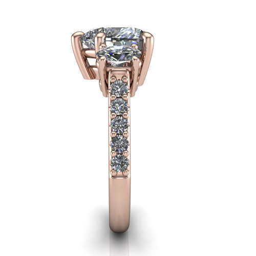 Poppy heart three stone engagement ring in 14K Rose Gold, side profile showing the round side stone and the pav&eacute; diamonds running down the shank