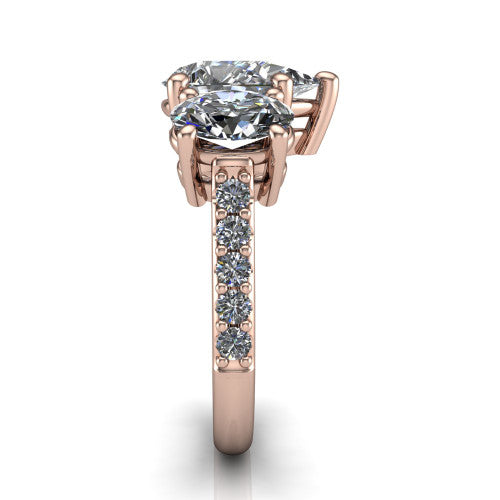 Poppy pear three stone engagement ring in 14K Rose Gold, side profile showing the round side stone and the pav&eacute; diamonds running down the shank