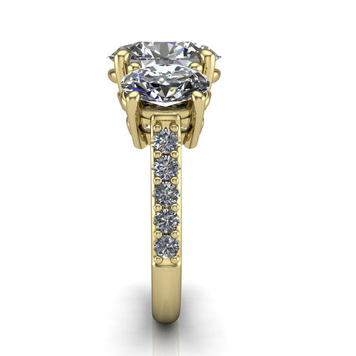 Poppy oval three stone engagement ring in 18K Yellow Gold, side profile showing the round side stone and the pav&eacute; diamonds running down the shank