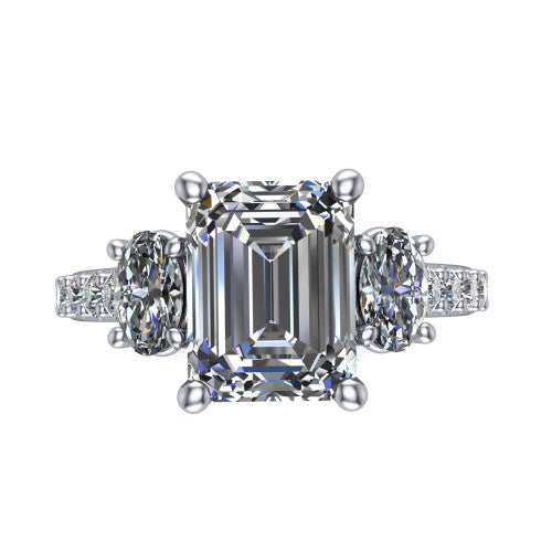 Poppy emerald three stone engagement ring in Platinum, top-down view showing the center diamond flanked by two round side stones in a classic three stone setting