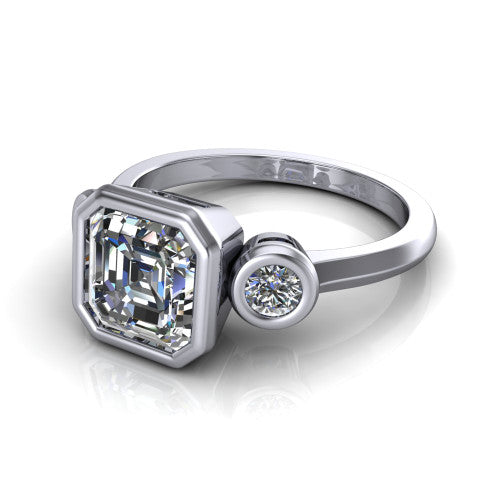Daisy asscher three stone engagement ring in 18K White Gold, three-quarter perspective showing the bezel-set center between two bezel-set round side stones on a slim polished band