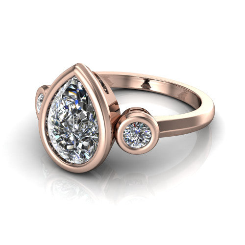 Daisy pear three stone engagement ring in 18K Rose Gold, three-quarter perspective showing the bezel-set center between two bezel-set round side stones on a slim polished band