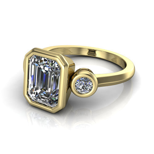 Daisy emerald three stone engagement ring in 18K Yellow Gold, three-quarter perspective showing the bezel-set center between two bezel-set round side stones on a slim polished band