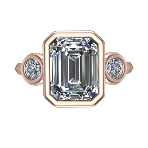 Daisy emerald three stone engagement ring in 18K Rose Gold, top-down view showing the bezel-set center diamond flanked by two round bezel-set side stones
