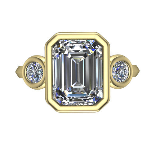 Daisy emerald three stone engagement ring in 18K Yellow Gold, top-down view showing the bezel-set center diamond flanked by two round bezel-set side stones
