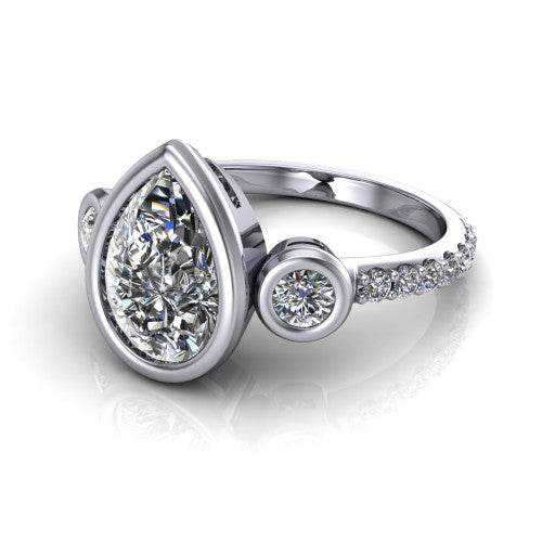 Chloe pear three stone engagement ring in Platinum, three-quarter perspective showing the bezel-set center between two bezel-set round side stones above a pav&eacute; shank