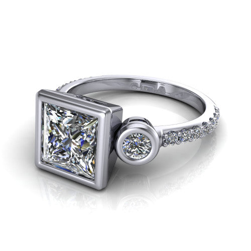 Chloe princess three stone engagement ring in Platinum, three-quarter perspective showing the bezel-set center between two bezel-set round side stones above a pav&eacute; shank