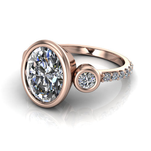 Chloe oval three stone engagement ring in 14K Rose Gold, three-quarter perspective showing the bezel-set center between two bezel-set round side stones above a pav&eacute; shank