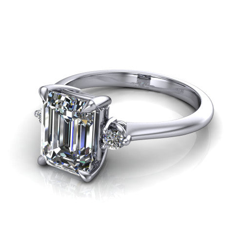 Olive emerald three stone engagement ring in Platinum, three-quarter perspective showing the center diamond between two round side stones on a slim polished band
