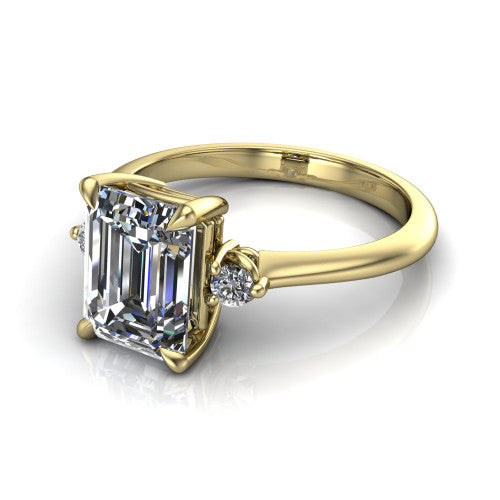 Olive emerald three stone engagement ring in 18K Yellow Gold, three-quarter perspective showing the center diamond between two round side stones on a slim polished band