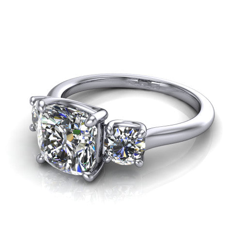 Emma cushion three stone engagement ring in Platinum, three-quarter perspective showing the center diamond between two round side stones on a slim polished band