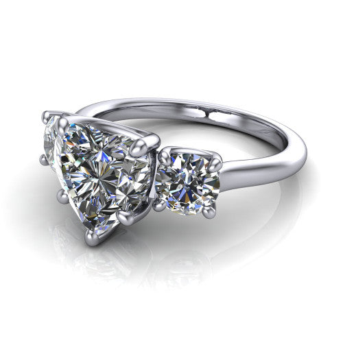 Emma heart three stone engagement ring in Platinum, three-quarter perspective showing the center diamond between two round side stones on a slim polished band