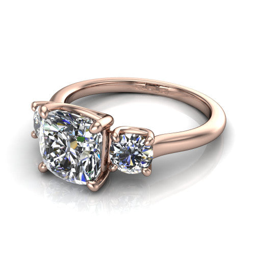Emma cushion three stone engagement ring in 14K Rose Gold, three-quarter perspective showing the center diamond between two round side stones on a slim polished band