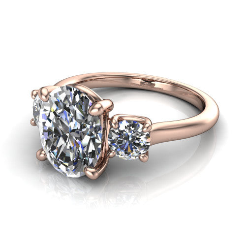 Emma oval three stone engagement ring in 14K Rose Gold, three-quarter perspective showing the center diamond between two round side stones on a slim polished band