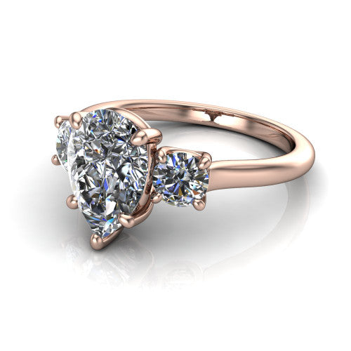 Emma pear three stone engagement ring in 14K Rose Gold, three-quarter perspective showing the center diamond between two round side stones on a slim polished band
