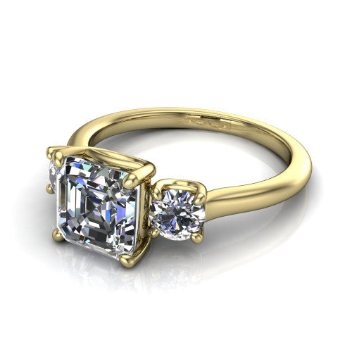 Emma asscher three stone engagement ring in 14K Yellow Gold, three-quarter perspective showing the center diamond between two round side stones on a slim polished band