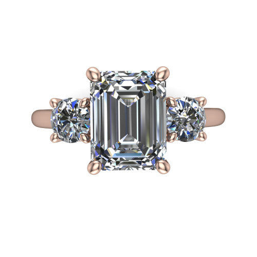Emma emerald three stone engagement ring in 18K Rose Gold, top-down view showing the center diamond flanked by two round side stones in a classic three stone setting