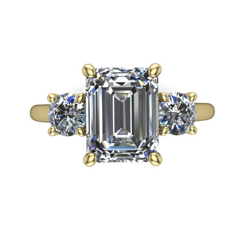 Emma emerald three stone engagement ring in 18K Yellow Gold, top-down view showing the center diamond flanked by two round side stones in a classic three stone setting