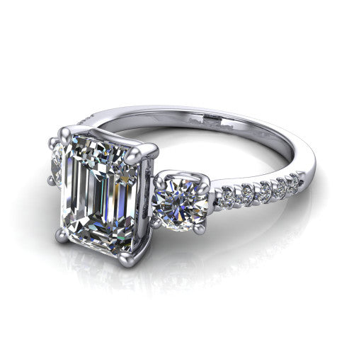 Celeste emerald three stone engagement ring in 18K White Gold, three-quarter perspective showing the center diamond between two round side stones above a pav&eacute; shank