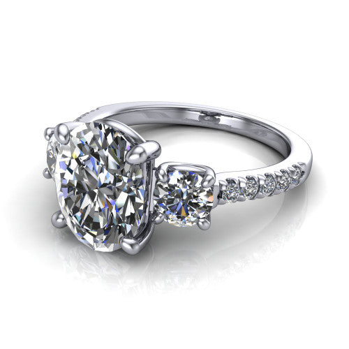 Celeste oval three stone engagement ring in Platinum, three-quarter perspective showing the center diamond between two round side stones above a pav&eacute; shank