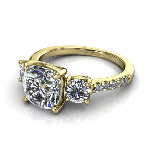 Celeste cushion three stone engagement ring in 18K Yellow Gold, three-quarter perspective showing the center diamond between two round side stones above a pav&eacute; shank