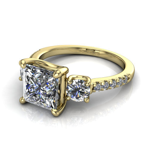 Celeste princess three stone engagement ring in 18K Yellow Gold, three-quarter perspective showing the center diamond between two round side stones above a pav&eacute; shank
