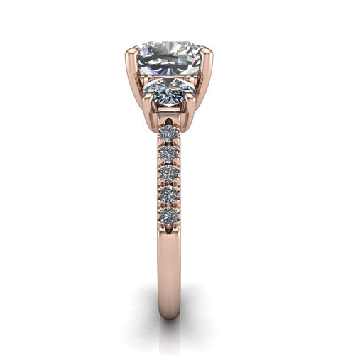 Celeste cushion three stone engagement ring in 14K Rose Gold, side profile showing the round side stone and the pav&eacute; diamonds running down the shank