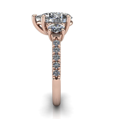 Celeste pear three stone engagement ring in 18K Rose Gold, side profile showing the round side stone and the pav&eacute; diamonds running down the shank