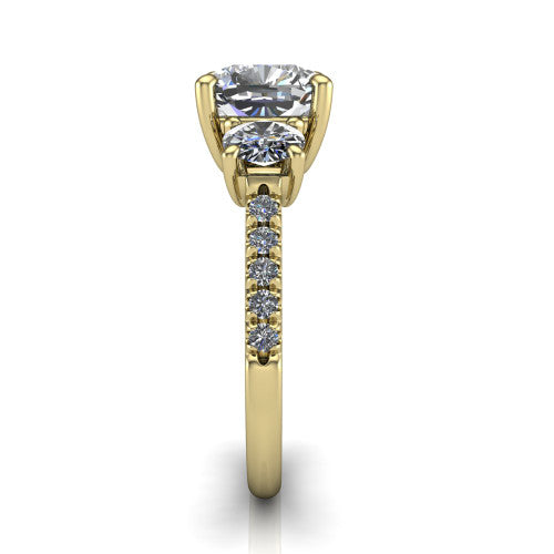 Celeste cushion three stone engagement ring in 14K Yellow Gold, side profile showing the round side stone and the pav&eacute; diamonds running down the shank