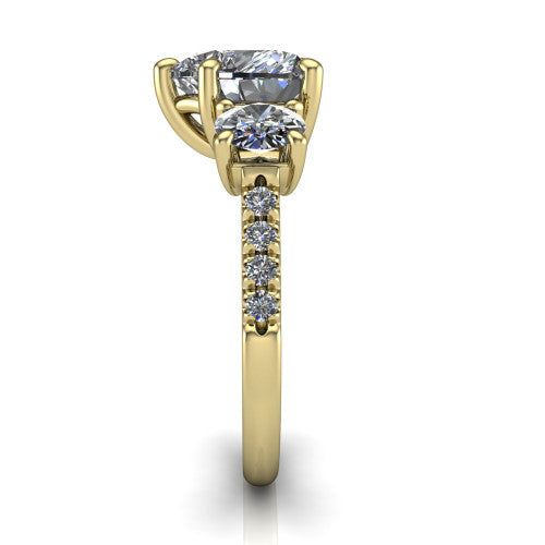 Celeste heart three stone engagement ring in 18K Yellow Gold, side profile showing the round side stone and the pav&eacute; diamonds running down the shank