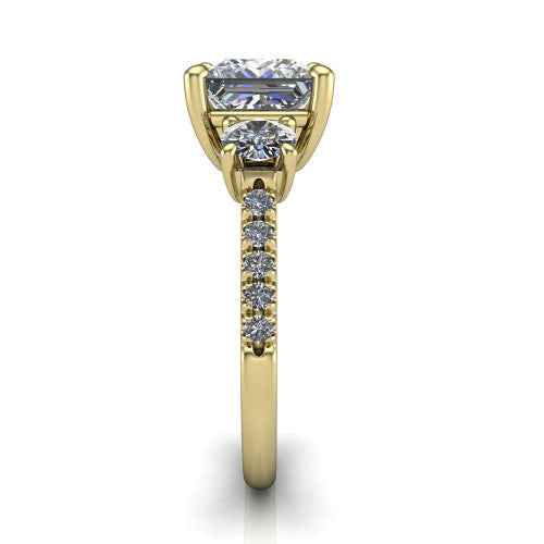 Celeste princess three stone engagement ring in 14K Yellow Gold, side profile showing the round side stone and the pav&eacute; diamonds running down the shank