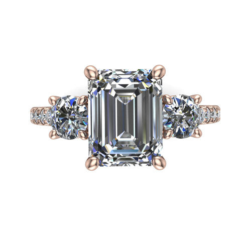 Celeste emerald three stone engagement ring in 18K Rose Gold, top-down view showing the center diamond flanked by two round side stones in a classic three stone setting
