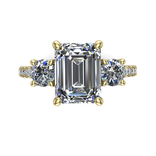 Celeste emerald three stone engagement ring in 14K Yellow Gold, top-down view showing the center diamond flanked by two round side stones in a classic three stone setting