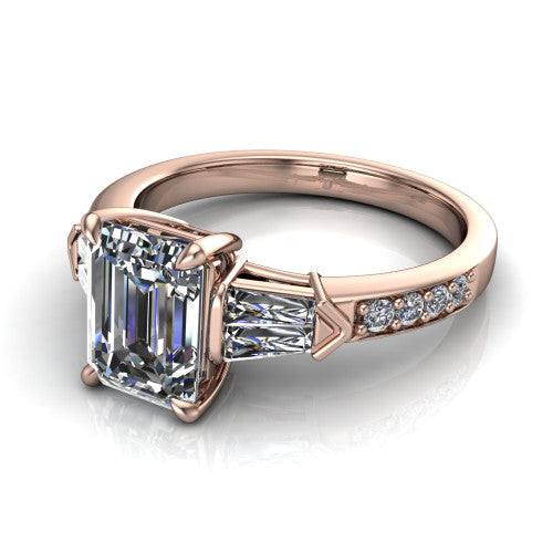 Audrey emerald three stone engagement ring in 18K Rose Gold, three-quarter perspective showing the center diamond between two tapered baguette side stones above a pav&eacute; band