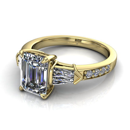 Audrey emerald three stone engagement ring in 18K Yellow Gold, three-quarter perspective showing the center diamond between two tapered baguette side stones above a pav&eacute; band