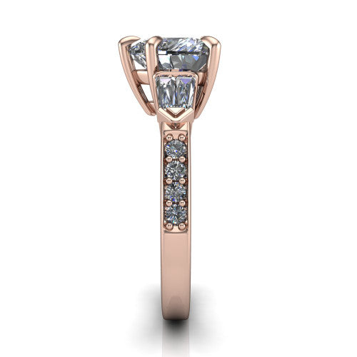 Audrey heart three stone engagement ring in 18K Rose Gold, side profile showing the tapered baguette side stone and the round diamonds running down the shank