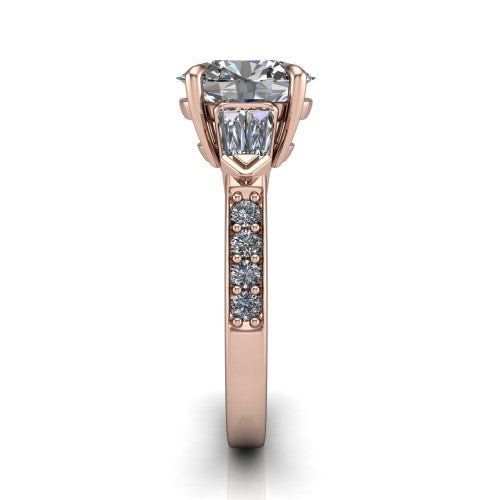 Audrey oval three stone engagement ring in 14K Rose Gold, side profile showing the tapered baguette side stone and the round diamonds running down the shank
