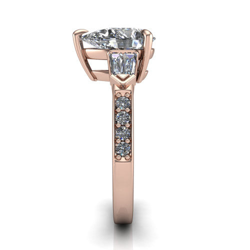 Audrey pear three stone engagement ring in 14K Rose Gold, side profile showing the tapered baguette side stone and the round diamonds running down the shank