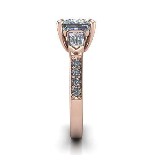 Audrey princess three stone engagement ring in 14K Rose Gold, side profile showing the tapered baguette side stone and the round diamonds running down the shank