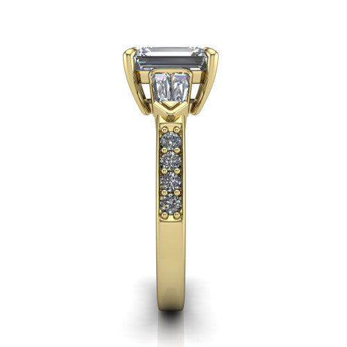 Audrey emerald three stone engagement ring in 14K Yellow Gold, side profile showing the tapered baguette side stone and the round diamonds running down the shank